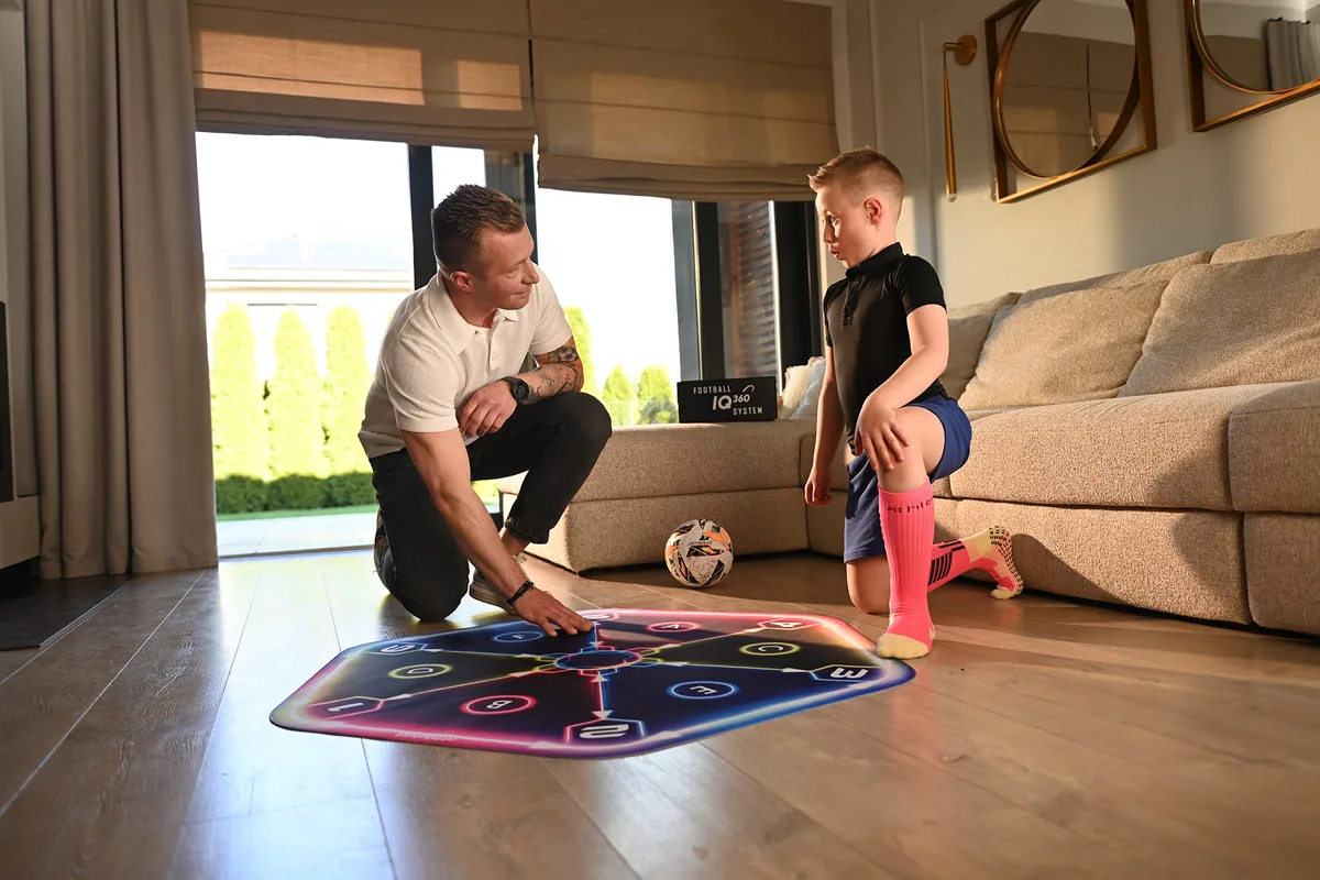 A parent and child setting up the Athlekid mat in a living room