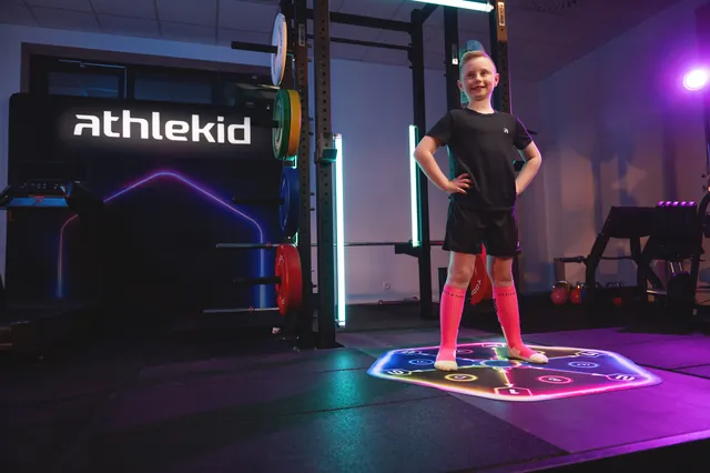 A frame from an Athlekid workout video on YouTube: a boy training on the mat